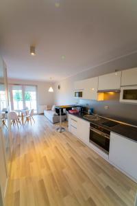 a kitchen and living room with a table and a couch at Wyspa Uznam - Platan in Świnoujście