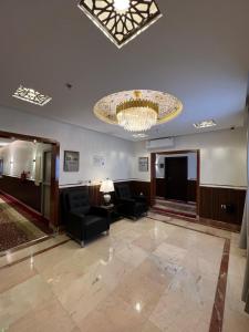 un gran vestíbulo con sillas y una lámpara de araña en فندق الليالي الحالمة en Medina