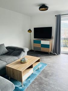 uma sala de estar com um sofá e uma mesa de centro em Ferienwohnung am Tor zum Thüringer Wald 2 em Plaue