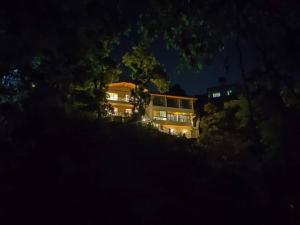 a large house on a hill at night at Windflower Villa in Mussoorie