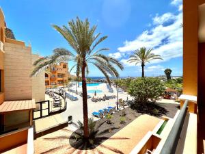 - Vistas a un complejo con piscina y palmeras en Family Apartment by the sea, Wifi, heated pool in South of Tenerife, en San Miguel de Abona