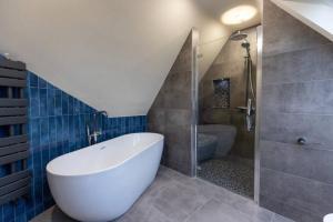 a bathroom with a large white tub and a shower at LUXURY TOWN CENTRE APARTMENT in Cookstown