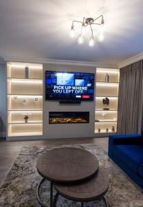 a living room with a tv and a couch and a table at LUXURY TOWN CENTRE APARTMENT in Cookstown