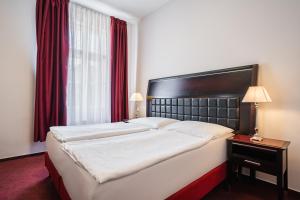 a bedroom with a large bed and a red window at EA Hotel Tosca in Prague