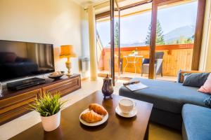 Televízia a/alebo spoločenská miestnosť v ubytovaní Mountain Apartments Butorowy Sauna Residence