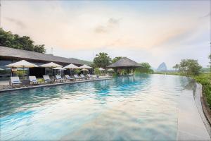 una piscina in un resort con sedie e ombrelloni di Serena Kim Boi Resort - Hoa Binh a Hòa Bình Altre 81 foto