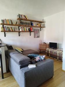 een woonkamer met een bank en planken aan de muur bij Intero appartamento zona centrale in Turijn