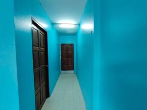 Ban Khok Mo的住宿－บ้านพักทนายบ้านนอก 2，一条空的走廊,有蓝色的墙壁和门
