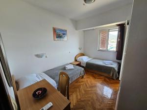 a small room with two beds and a table at Guest House Mamut in Kaštela