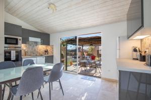 a kitchen and dining room with a table and chairs at El Sama-In , Piscine chauffée in L'Isle-sur-la-Sorgue