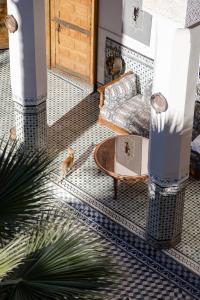 a living room with a couch and a table on a tiled floor at Riad 4 jardins in Marrakesh