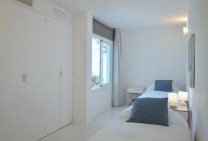 ポルト・ダンドラッチにあるVilla Sant Carlesの白いベッドルーム(ベッド1台、窓付)