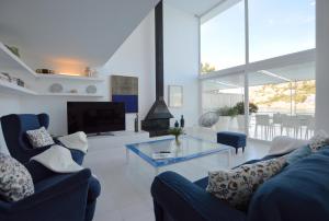 - un salon avec deux canapés bleus et une télévision dans l'établissement Villa Sant Carles, à Port d’Andratx