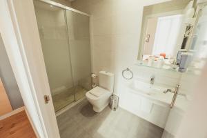 Un baño blanco con inodoro y lavabo. en Hostal Live Natura Barcelona, en Barcelona 29 fotos más