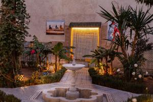 a garden with a fountain in the middle of a courtyard at Riad 4 jardins in Marrakesh