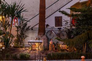 uma mesa e uma árvore em frente a uma casa em Riad 4 Jardins & Spa em Marrakech