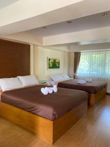 Ban Muang Ton Mamuang的住宿－三M山區度假酒店，卧室内的两张床和毛巾