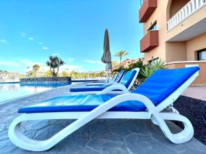 un grupo de tumbonas junto a la piscina en Family Apartment by the sea, Wifi, heated pool in South of Tenerife, en San Miguel de Abona