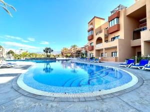 una gran piscina frente a un edificio en Family Apartment by the sea, Wifi, heated pool in South of Tenerife, en San Miguel de Abona