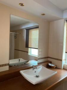 a bathroom with a sink and a large mirror at The Triple M Mountain Resort in Ban Muang Ton Mamuang