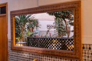 a mirror reflection of a balcony with plants at Riad 4 jardins in Marrakesh