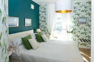 sypialnia z dużym białym łóżkiem z zielonymi poduszkami w obiekcie Residenza Echia w mieście Napoli