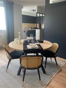 een eettafel en stoelen in een kamer bij Le Boudoir du Palais Climatisé & Luxueux in Périgueux