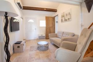 a living room with a couch and a table at El Sama-In , Piscine chauffée in L'Isle-sur-la-Sorgue