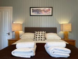 a bedroom with a bed with two towels on it at Fayvan Apartments in Whitby