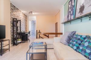 uma sala de estar com um sofá branco e uma televisão em Glyfada 2 bedrooms 4 persons apartment by MPS em Atenas