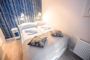- une chambre avec 2 lits dotés de draps et d'oreillers blancs dans l'établissement Apartamenty Sun & Snow Centrum Cicha, à Krynica-Zdrój