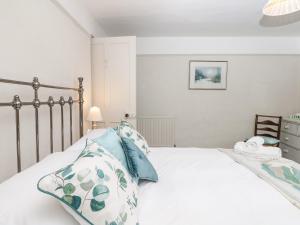 um quarto com uma grande cama branca com almofadas azuis em The Bathing House em Ashsprington