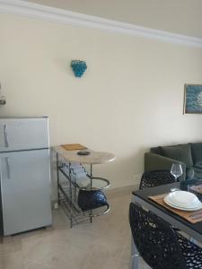 een keuken met een koelkast, een tafel en een bank bij EL MANZEl 102 in Houmt Souk