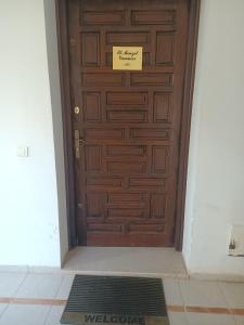 een houten deur met een bord erop bij EL MANZEl 102 in Houmt Souk