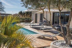 einen Pool mit Liegestühlen und ein Haus in der Unterkunft In Elsama piscine chauffée in LʼIsle-sur-la-Sorgue