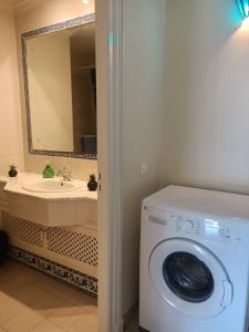een badkamer met een wasmachine en een wastafel bij EL MANZEl 102 in Houmt Souk