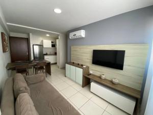 sala de estar con sofá y TV de pantalla plana en Beach Class Excelsior en Recife