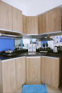 a kitchen with wooden cabinets and a blue rug at Santorini at Vertis North in Manila