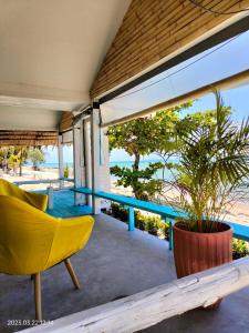 a yellow chair and a plant on a patio at Sand Terrace Beach Bungalows in Ban Tai