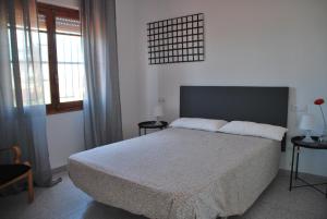 a bedroom with a large bed and two windows at villa beltran in Vinarós