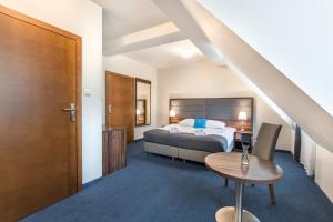 pokój hotelowy z łóżkiem i stołem w obiekcie Apartamenty Rynek 20 w Pszczynie