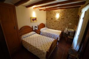 a hotel room with two beds and a table at La Posada in Cantavieja