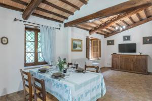 a dining room with a table and a television at Casina del Bosco in Santo