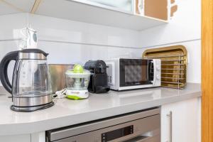 eine Küchentheke mit einem Mixer und einer Mikrowelle in der Unterkunft ApartUP Patacona Sunrise Duplex in Valencia