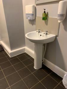 baño con lavabo blanco y suelo de baldosa. en The Prince Alfred en Liverpool
