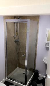 a shower with a glass door in a bathroom at Carnegie Lodge Hotel in Tain