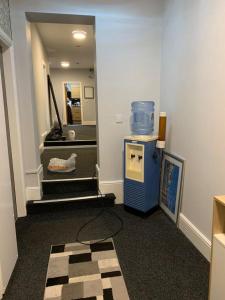 um corredor com escadas e uma caixa azul no chão em The Prince Alfred em Liverpool