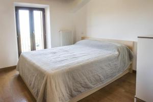 a bed in a white room with a window at Grazioso Bilocale a 5 minuti da Numana in Numana
