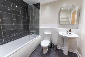 a bathroom with a toilet and a sink and a bath tub at ALTIDO Modern flats in central Birmingham, next to business district in Birmingham