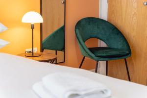 a room with a green chair and a lamp at ALTIDO Modern flats in central Birmingham, next to business district in Birmingham